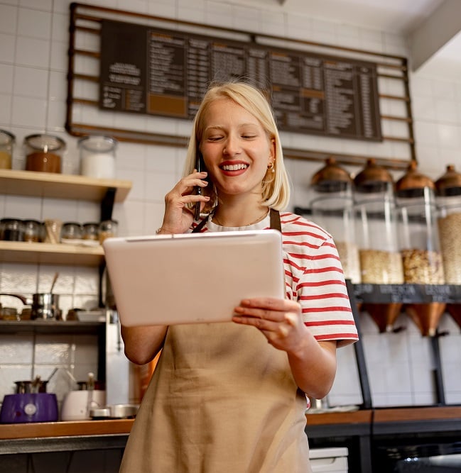 Male and female employees in a bakery holding a tablet and talking